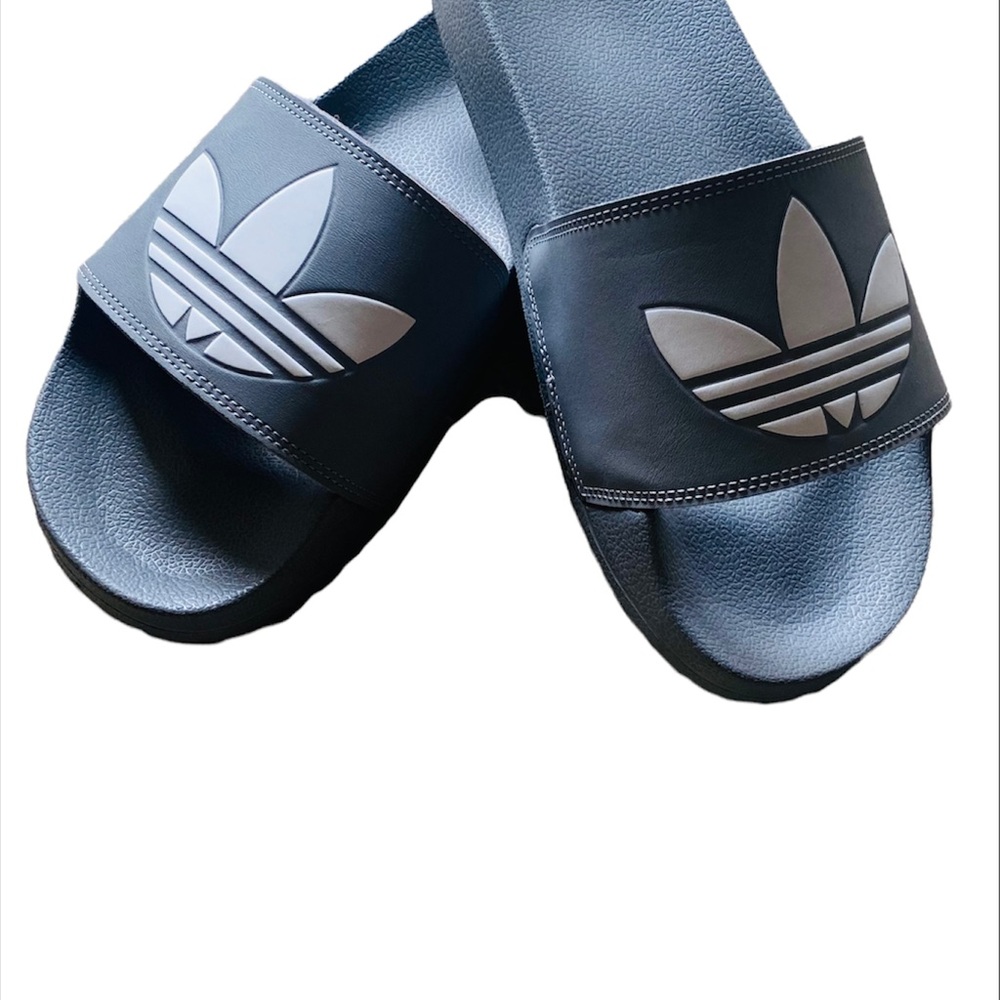 Grey and White Adidas slides.